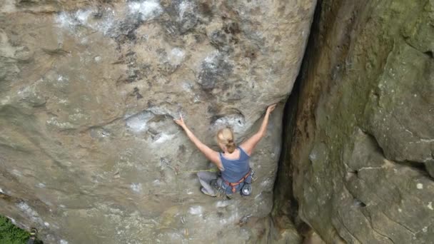 Junge Frau klettert steile Felswand hinauf. Bergsteigerin überwindet anspruchsvolle Route Engagement im Extremsportkonzept — Stockvideo