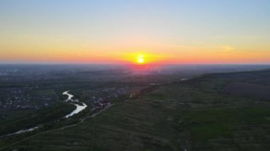 Yeşil ekili tarlaların, büyüyen ekinlerin ve parlak yaz akşamlarında uzak köy evlerinin hava manzarası.