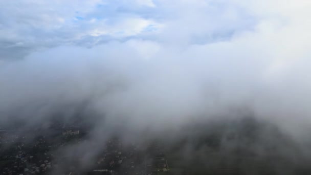 Αεροφωτογραφία από το μεγάλο υψόμετρο της μακρινής πόλης καλυμμένη με φουσκωτά σύννεφα που σχηματίζονται πριν από την καταιγίδα — Αρχείο Βίντεο