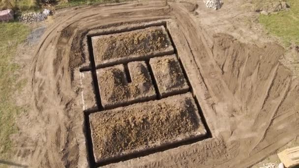 Ausgegrabener Graben für Bauarbeiten an neuem Hausbetonfundament auf Baustelle — Stockvideo