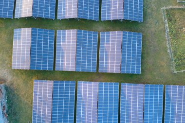 Temiz ekolojik elektrik enerjisi üretmek için sıra sıra güneş fotovoltaik panelleri olan sürdürülebilir büyük elektrik santralinin havadan görünüşü. Sıfır emisyon kavramı ile yenilenebilir elektrik.