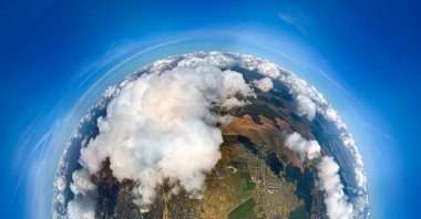 Güneşli bir günde, küçük gezegen Dünya 'nın beyaz kabarık kümülüs bulutlarıyla kaplı yüksek irtifasından hava manzarası.