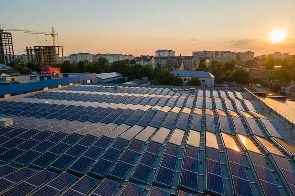 Mavi fotovoltaik güneş panelleri gün batımında temiz ekolojik elektrik üretmek için çatıya monte edildi. Yenilenebilir enerji konsepti üretimi — Stok fotoğraf
