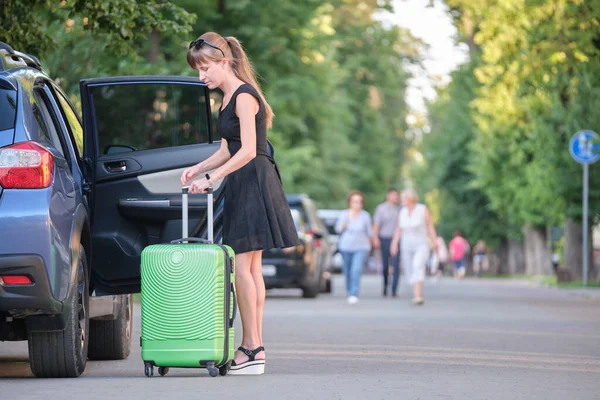 Jovem condutora a tirar a mala da mala do carro. Viagens e férias conceito — Fotografia de Stock