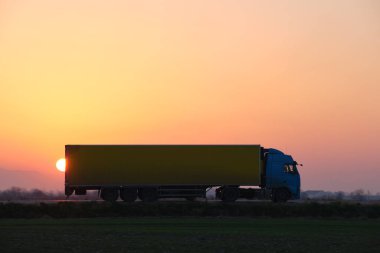 Kargo karavanı olan yarı kamyon akşam vakti otobanda mal taşır. Teslimat ulaşım ve lojistik kavramı