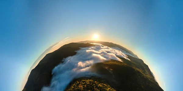 Vue aérienne depuis la haute altitude de la petite planète Terre au lever du soleil couverte de forêts à feuilles persistantes et de sommets de haute montagne — Photo