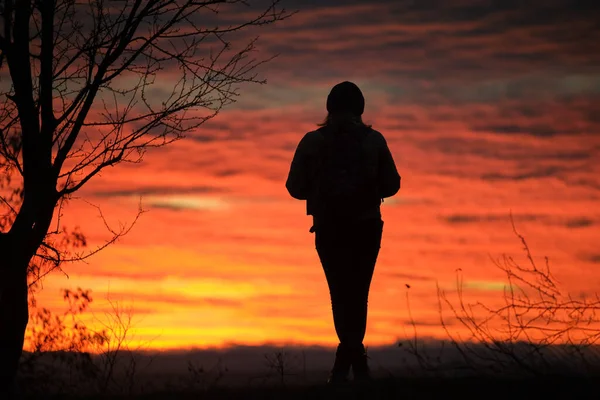Dark silhouette of a lonely woman enjoying sunset view in evening nature. Loneliness and solitude concept — 图库照片