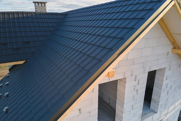 Vue aérienne de la maison inachevée avec murs en béton léger aéré et cadre de toit en bois recouvert de tuiles métalliques en construction — Photo