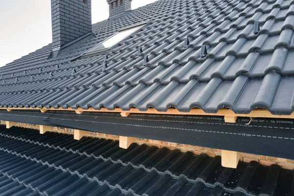 Closeup of house roof top covered with ceramic shingles. Tiled covering of building under construction — Stock Photo, Image