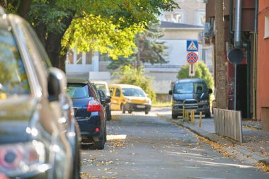 Sokak kenarında park halinde bir sürü araba olan şehir trafiği.