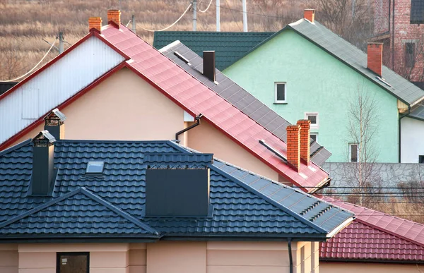 農村部郊外の金属とセラミックの帯状疱疹で覆われた屋根の上の住宅 — ストック写真