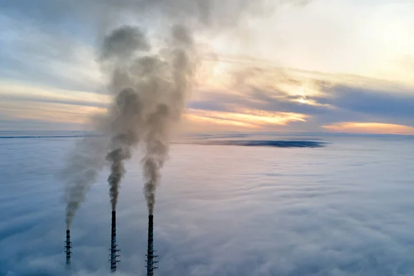 Uitzicht vanuit de lucht op hoge pijpen van kolencentrales met zwarte rook die bij zonsondergang de vervuilende atmosfeer opgaat — Stockfoto