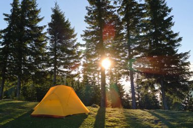 Parlak güneşli bir akşamda dağ kamp alanında turist kampı çadırı. Aktif turizm ve yürüyüş konsepti