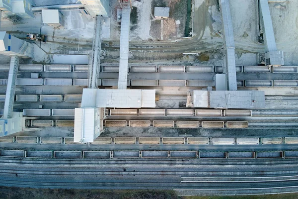 Vista aérea del tren de carga cargado con materiales de piedra triturada en la fábrica minera. Transporte ferroviario de mineral de piedra caliza molida — Foto de Stock