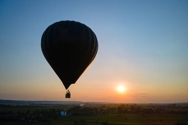 Flygfoto över stora varmluftsbaloon flyger över landsbygden i solnedgången — Stockfoto
