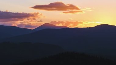 Güzel bir akşam panoramik manzarası. Gün batımında uzak dağ tepeleri üzerinde parlak batan güneş.