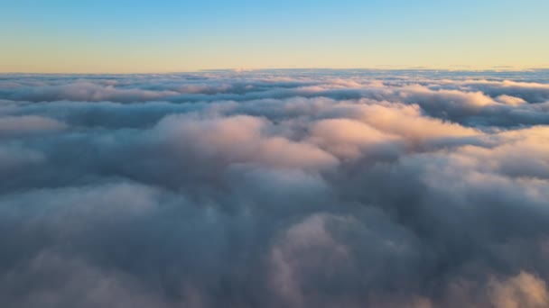 Aerial view from above at high altitude of dense puffy cumulus clouds flying in evening. Amazing sunset from airplane window point of view — 图库视频影像