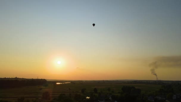 Flygfoto över stora varmluftsbaloon flyger över landsbygden i solnedgången — Stockvideo