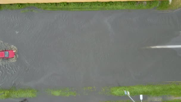 Widok z powietrza na ruch miejski z samochodami jadącymi po zalanej ulicy po ulewnym deszczu. Problemy z systemem odwodnienia dróg — Wideo stockowe