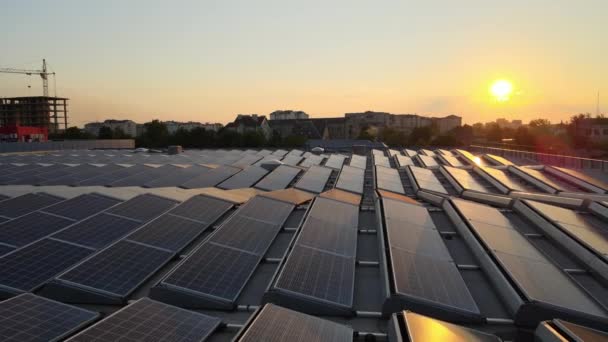 Mavi fotovoltaik güneş panelleri gün batımında temiz ekolojik elektrik üretmek için çatıya monte edildi. Yenilenebilir enerji konsepti üretimi — Stok video