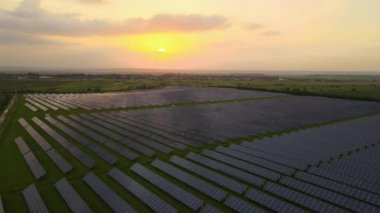 Akşamları temiz elektrik enerjisi üretmek için sıra sıra güneş fotovoltaik panelleri olan sürdürülebilir büyük elektrik santralinin havadan görünüşü. Sıfır emisyonlu yenilenebilir elektrik kavramı