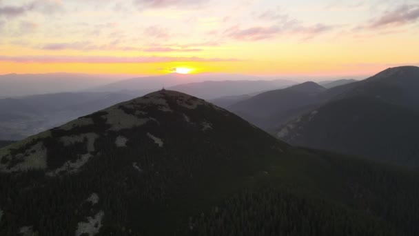 明るい夕日で濃い松の森の木々と高いピーク時の霧の夜の空中ビュー。夕暮れ時の野生の山の森の素晴らしい景色 — ストック動画