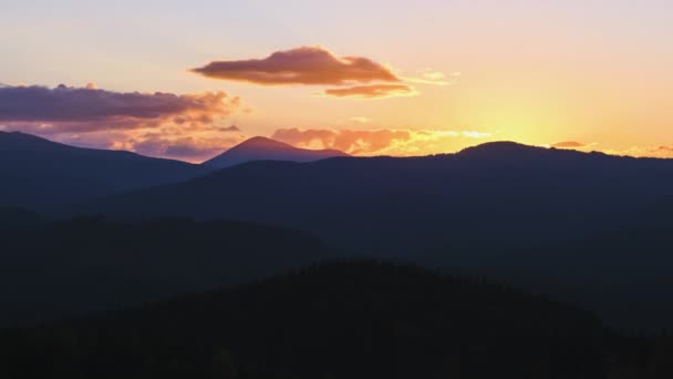 Hermoso paisaje panorámico de la noche con sol poniente brillante sobre picos de montaña distantes al atardecer — Vídeos de Stock