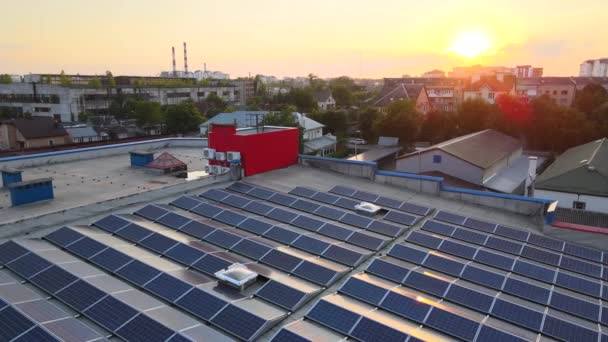Paneles solares fotovoltaicos azules montados en el techo del edificio para producir electricidad ecológica limpia al atardecer. Concepto de producción de energías renovables — Vídeos de Stock