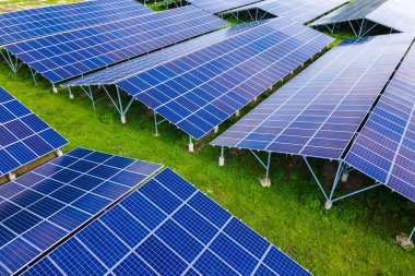 Temiz ekolojik elektrik enerjisi üretmek için sıra sıra güneş fotovoltaik panelleri olan sürdürülebilir büyük elektrik santralinin havadan görünüşü. Sıfır emisyon kavramı ile yenilenebilir elektrik