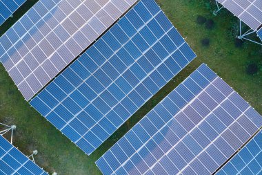 Temiz ekolojik elektrik enerjisi üretmek için sıra sıra güneş fotovoltaik panelleri olan sürdürülebilir büyük elektrik santralinin havadan görünüşü. Sıfır emisyon kavramı ile yenilenebilir elektrik.