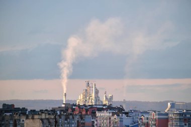 Yüksek fabrika yapısına sahip çimento fabrikası ve şehir merkezi yakınlarındaki endüstriyel üretim alanındaki vinçler. Üretim ve küresel sanayi kavramı