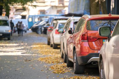 Sokak kenarında park halinde bir sürü araba olan şehir trafiği.