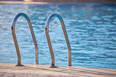 Yüzme havuzuna yakın paslanmaz çelik korkuluklar kaplumbağaların temiz havuz suyuna iniyor. Eğlence etkinlikleri kavramının erişilebilirliği