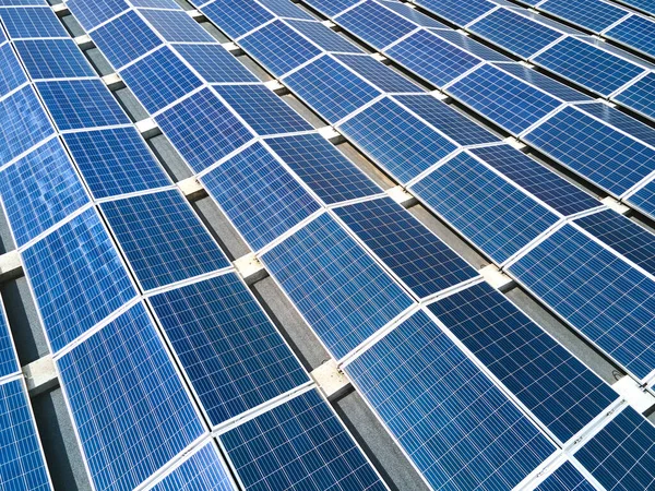 Flygfoto av blå solceller solpaneler monterade på industribyggnad tak för att producera grön ekologisk el. Produktion av begreppet hållbar energi — Stockfoto