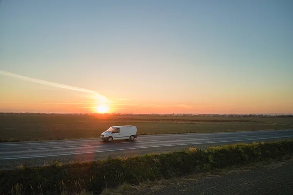 Vista aérea da estrada interurbana com carro de condução rápido borrado ao pôr do sol. Vista superior do drone do tráfego rodoviário à noite — Fotografia de Stock