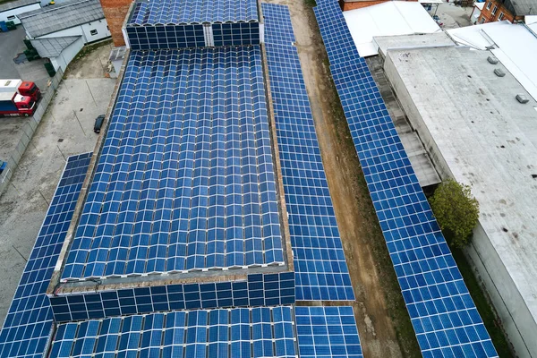 Veduta aerea della centrale solare con pannelli fotovoltaici blu montati sul tetto dell'edificio industriale per la produzione di energia elettrica ecologica verde. Produzione di concetto di energia sostenibile — Foto Stock