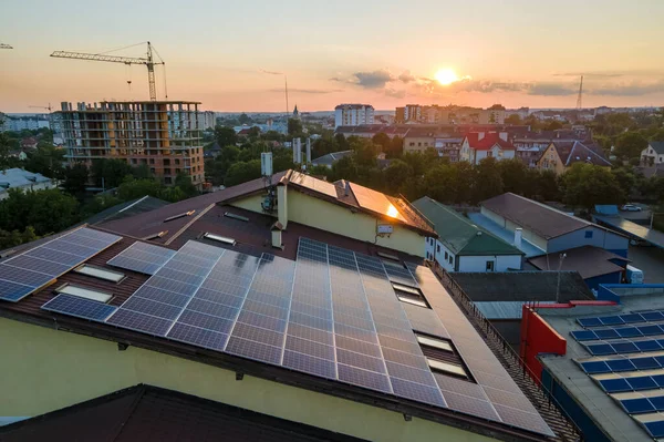 Mavi fotovoltaik güneş panelleri gün batımında temiz ekolojik elektrik üretmek için çatıya monte edildi. Yenilenebilir enerji konsepti üretimi — Stok fotoğraf