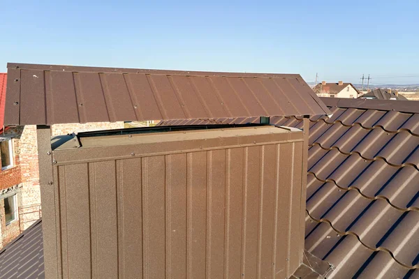 Camino sul tetto della casa coperto con tegole metalliche in costruzione. Copertura piastrellata di edificio. Sviluppo immobiliare — Foto Stock