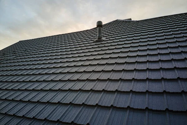 Detailní záběr střechy domu pokryté kovovými šindely.Dlažba krytiny budovy — Stock fotografie