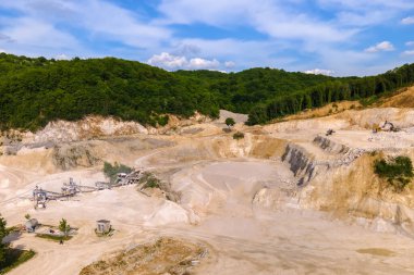 Kazı makineleri ve çöp kamyonlarıyla inşaat kum taşı malzemesi madenciliği