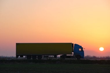 Kargo karavanı olan yarı kamyon akşam vakti otobanda mal taşır. Teslimat ulaşım ve lojistik kavramı