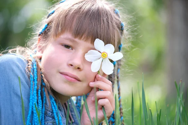 Glad barn flicka njuter söt lukt av vita narcissus blommor i sommar trädgård — Stockfoto