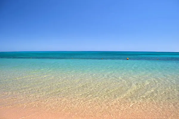 黄色の砂浜に小さなリップル波がクラッシュして青い海の水の表面と海の風景。旅行と休暇のコンセプト — ストック写真