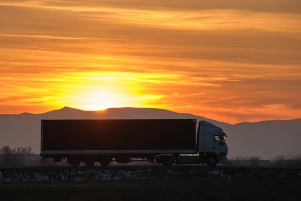 Semi-vrachtwagen met lading aanhangwagen rijden op de snelweg vervoeren goederen in de avond. Levering transport en logistiek concept — Stockfoto