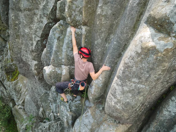 Sterke mannelijke klimmer klimmende steile muur van rotsachtige berg. Sportman overwint moeilijke route. Betrokken bij extreme sport hobby concept — Stockfoto