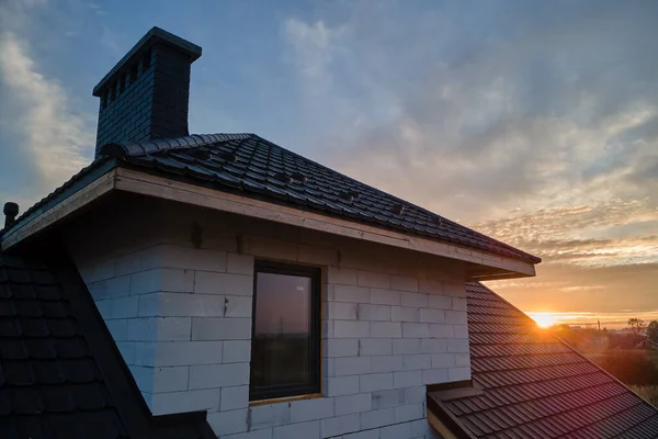 Незаконченный дом с газобетонными легкими стенами и деревянной рамой крыши, покрытой металлической черепицей в стадии строительства — стоковое фото