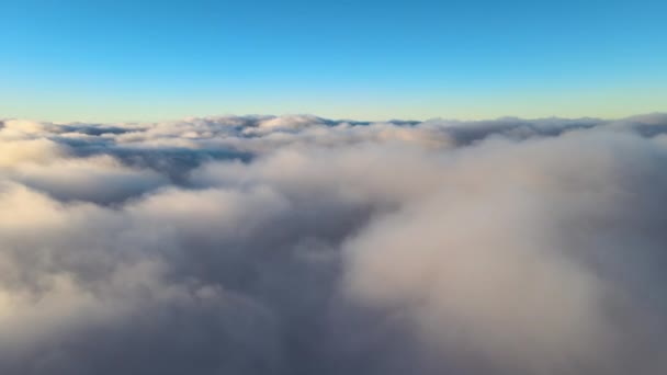 มุมมองทางอากาศจากด้านบนที่ความสูงของเมฆสะสมปุยหนาแน่นบินในตอนเย็น พระอาทิตย์ตกที่น่าตื่นตาตื่นใจจากมุมมองหน้าต่างเครื่องบิน — วีดีโอสต็อก