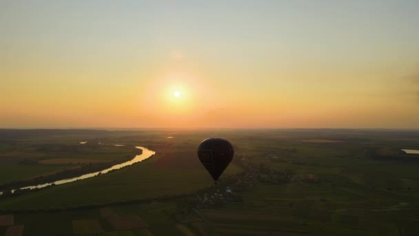 Vista aerea di grande mongolfiera che sorvola la campagna rurale al tramonto — Video Stock