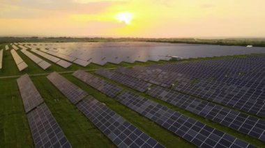 Akşamları temiz elektrik enerjisi üretmek için sıra sıra güneş fotovoltaik panelleri olan sürdürülebilir büyük elektrik santralinin havadan görünüşü. Sıfır emisyonlu yenilenebilir elektrik kavramı