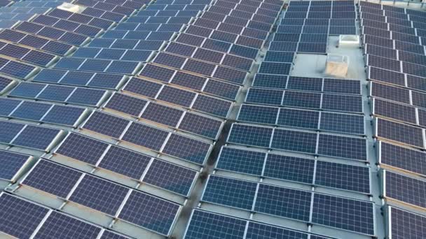 Luchtfoto van blauwe fotovoltaïsche zonnepanelen gemonteerd op industrieel gebouwendak voor de productie van groene ecologische elektriciteit. Productie van concept voor duurzame energie — Stockvideo